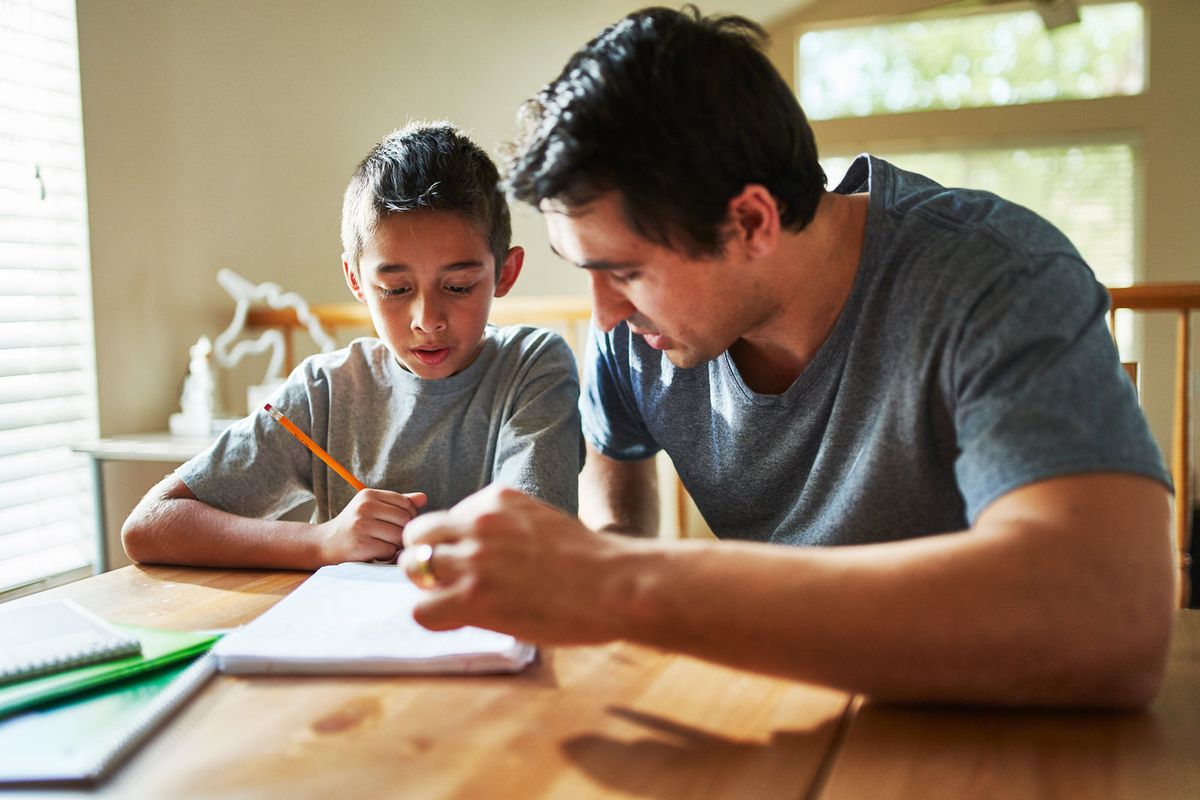 A tutor working through schoolwork with a young student