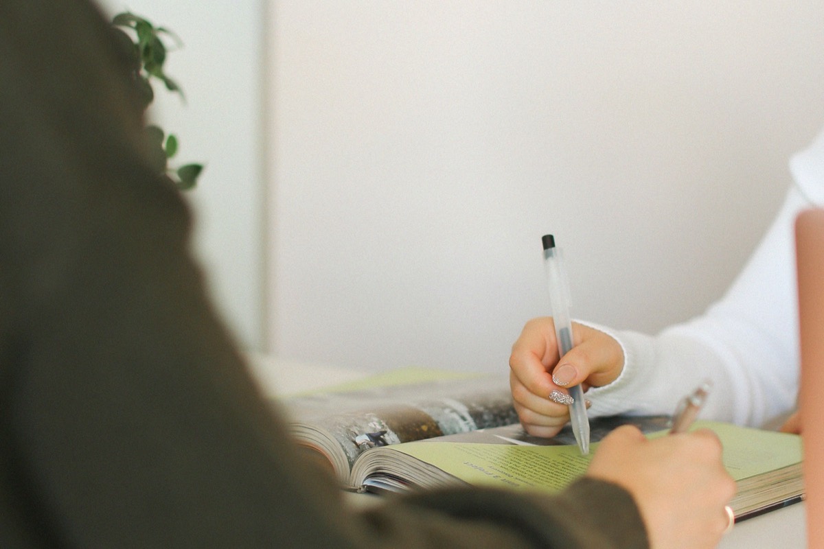 A tutor guiding a student through their work at a desk