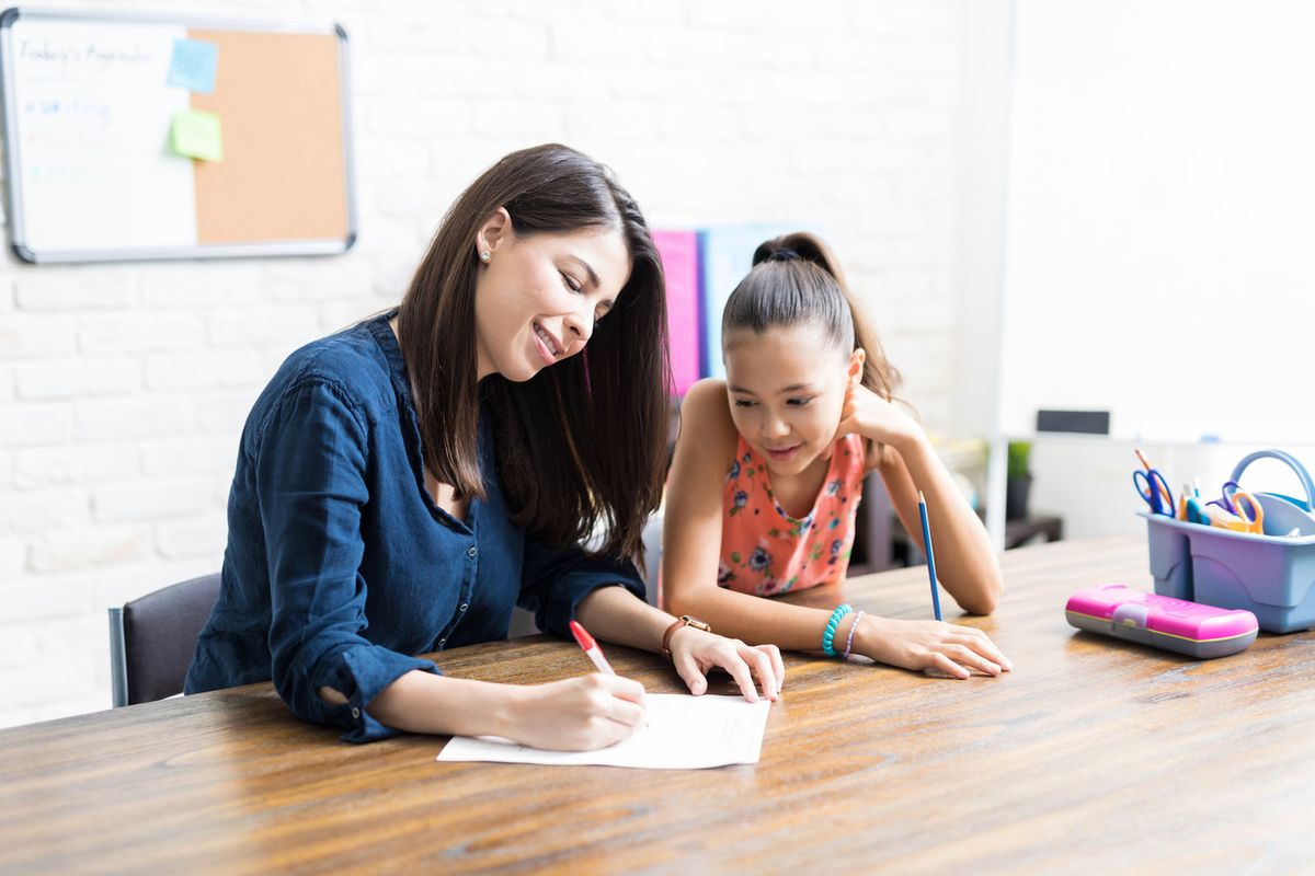 A tutor working one-on-one with a student at a table